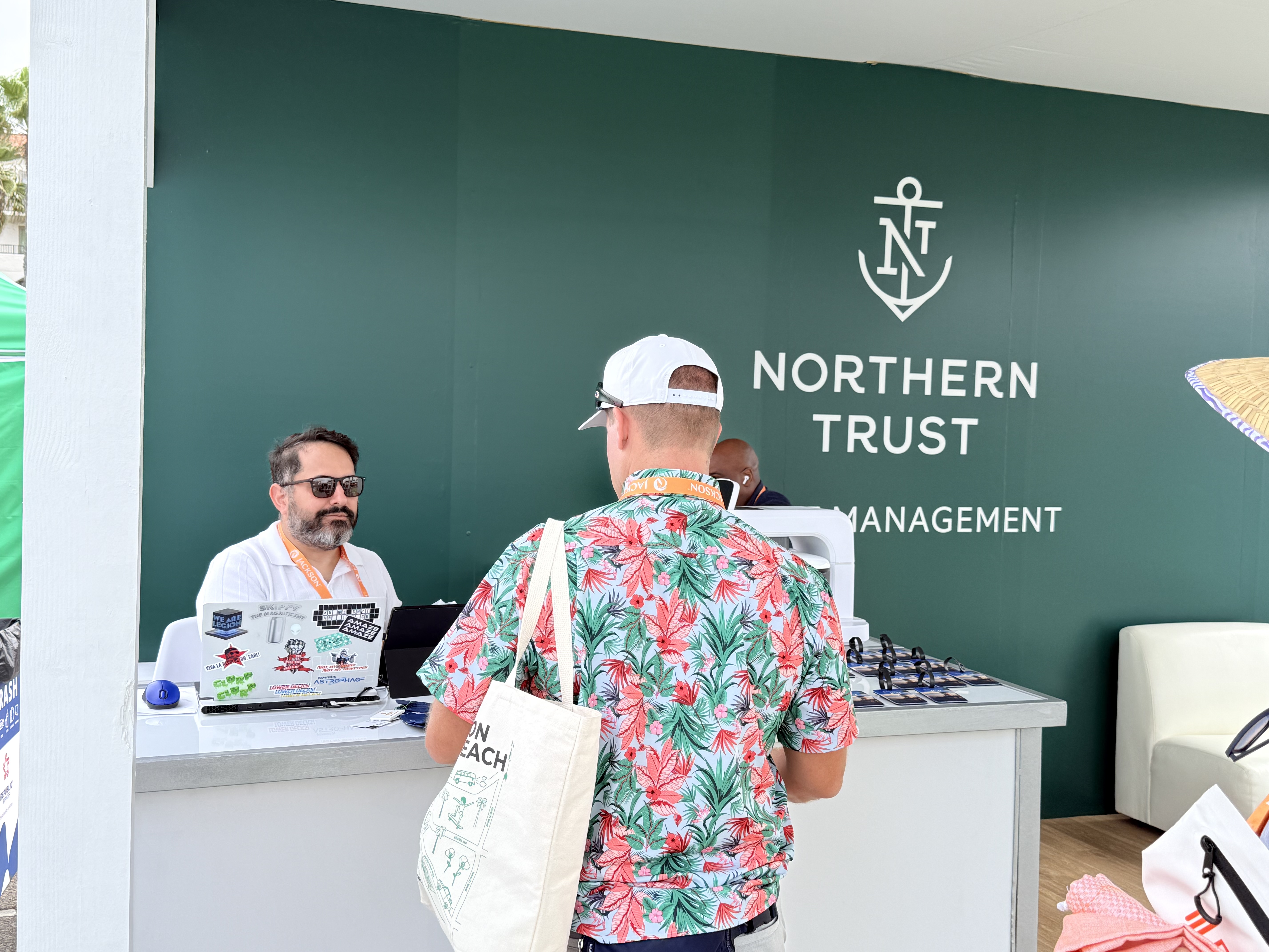 A guest at the Northern Trust counter choosing a tag from the finished pieces on the rail