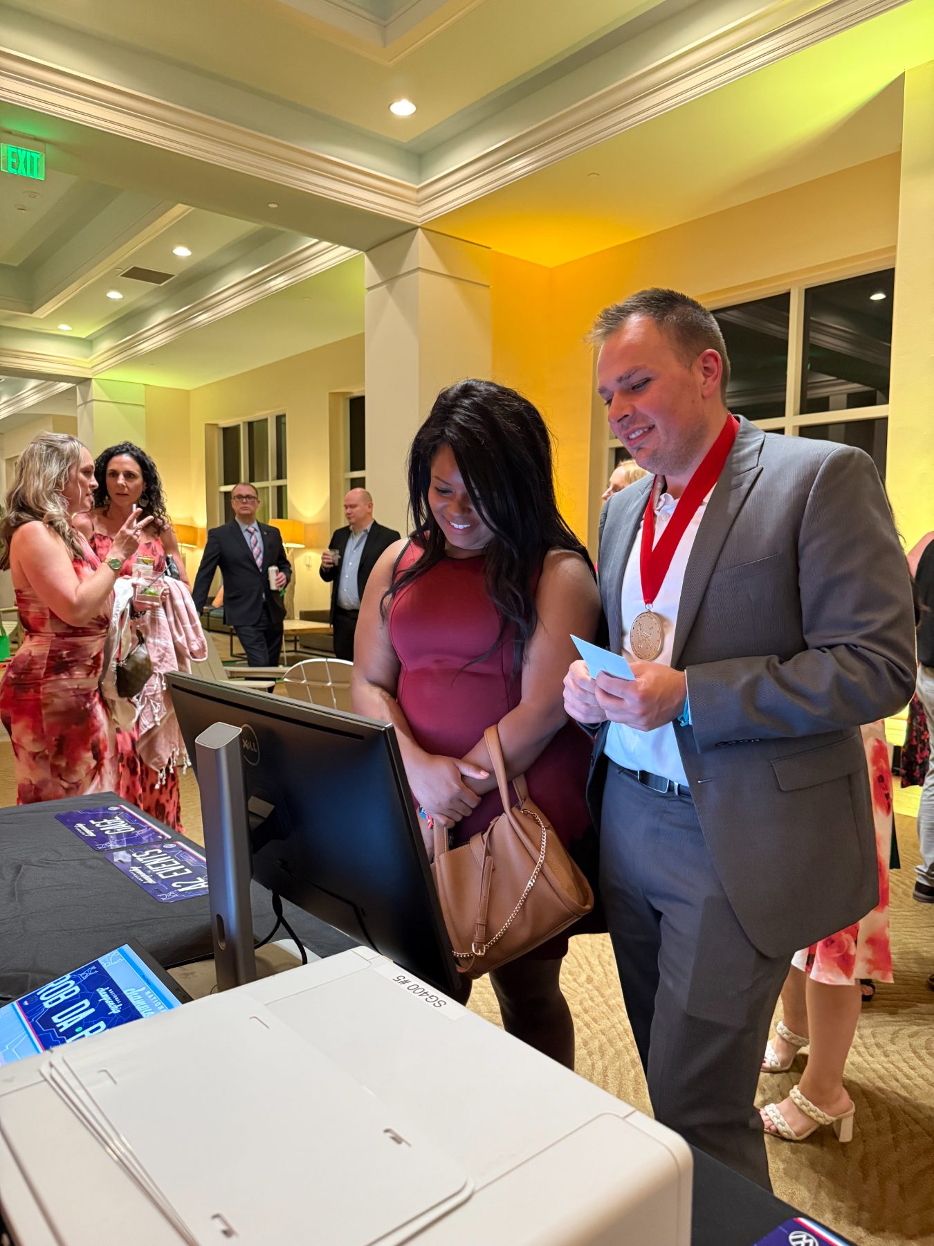Two guests at the Southeast Volkswagen Group celebration watching their custom license plate being made at the station