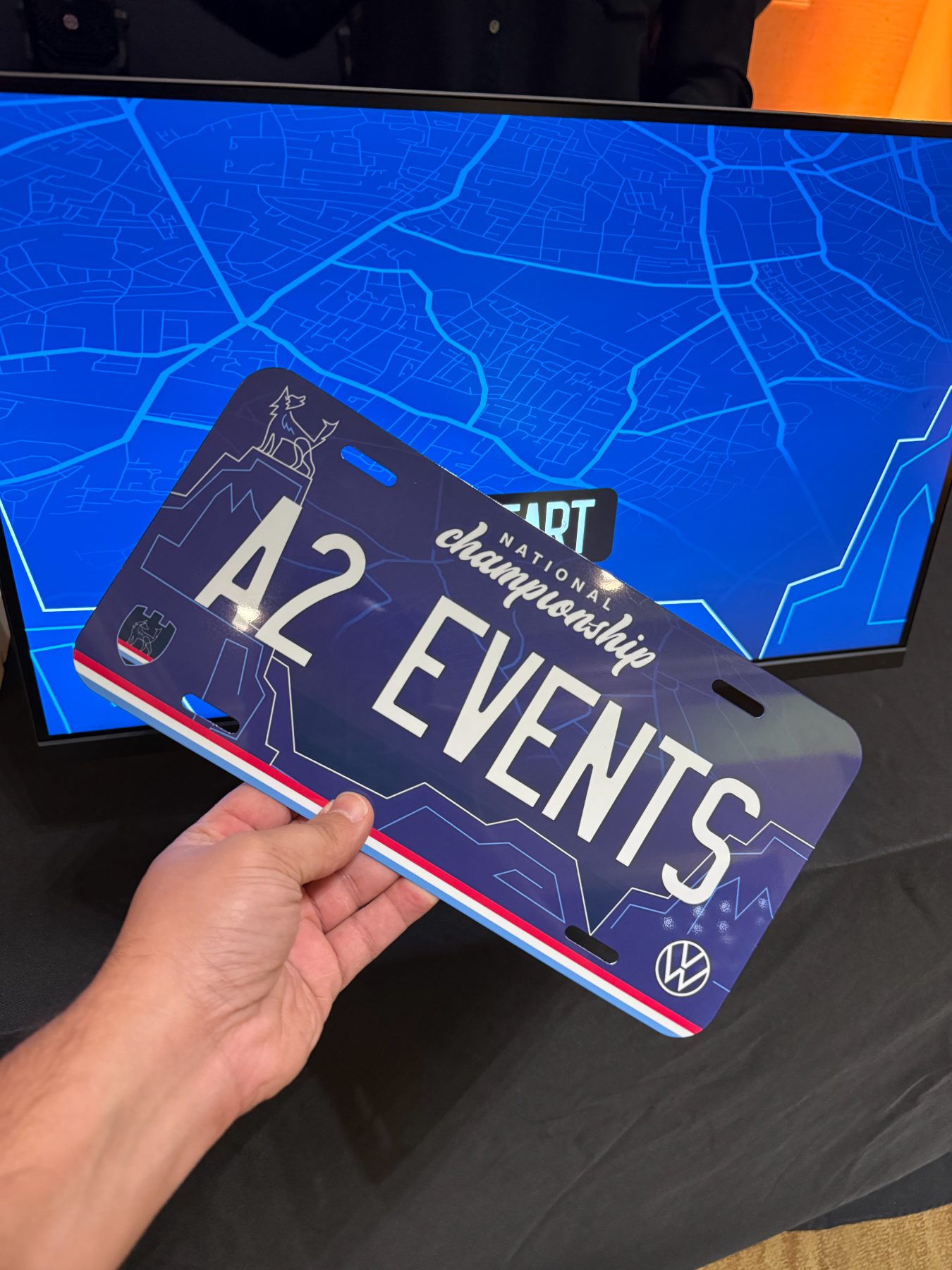 A finished full color vanity plate reading A2 EVENTS held in front of the station monitor